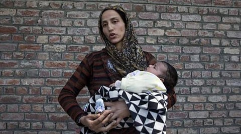 இரவு நேர ரெய்டில் கணவரைக் கைது செய்ததையடுத்து ஆகஸ்ட் 20, 2019 அன்று, பிறந்து 40 நாட்களேயான குழந்தையுடன் ஸ்ரீநகர் காவல்நிலையத்துக்கு வெளியே காத்திருக்கும் பெண். | ஏ.பி.