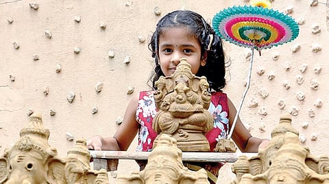 விநாயகர் சதுர்த்தி இன்று கொண்டாடப்படுகிறது. இதையொட்டி சென்னை மயிலாப்பூர் லஸ் கார்னரில் சாலையோரக் கடையில் இருந்து வாங்கிய களிமண் விநாயகரை பலகையில் வைத்து எடுத்துச் செல்லும் சிறுமி.படம்: க.ஸ்ரீபரத்