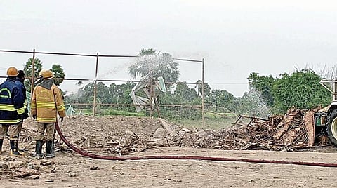 வெடி விபத்து நடந்த இடத்தில் தண்ணீரை பீய்ச்சி அடிக்கும் தீயணைப்பு வீரர்கள்.