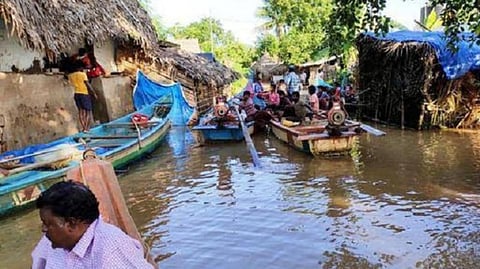 வெள்ளத்திலிருந்து வெளியேறும் கிராம மக்கள்.