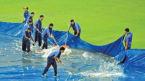 தரம்சாலா மைதானத்தில் தேங்கியுள்ள நீரை அகற்றும் பணியில் ஈடுபட்டுள்ள மைதான ஊழியர்கள் | படம்: அகிலேஷ் குமார்