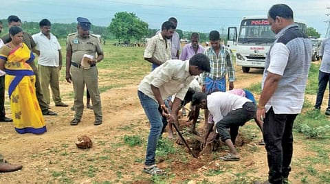சிறுமுகை அருகே பொகலூரில் நிலத்தை தோண்டி மாரிமுத்துவின் சடலத்தை தேடும் பணியில் ஈடுபட்டுள்ள காவல்துறையினர் .