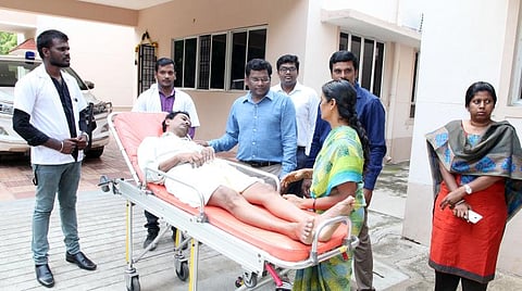 மேல் சிகிச்சைக்காக புறப்பட்டு சென்ற நெசவுத் தொழிலாளி வேல்முருகனின் உடல்நலம் குறித்து கேட்டறிந்த ஆட்சியர் கந்தசாமி.