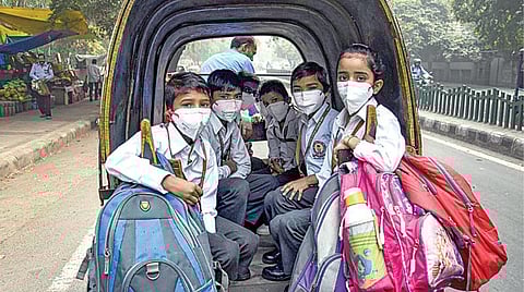 டெல்லியில் காற்று மாசு அபாய அளவைத் தாண்டியதால் குழந்தைகள் முக கவசம் அணிந்து பள்ளிக்குச் சென்றனர்.படம்: பிடிஐ