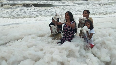 பட்டினப்பாக்கத்தில் படர்ந்திருக்கும் நுரையுடன் விளையாடும் குழந்தைகள் | படம்: எல்.சீனிவாசன்