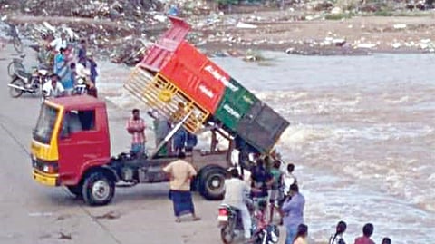 திட்டக்குடி வெள்ளாற்றில் குப்பையை கொட்டும் பேரூராட்சி லாரி.