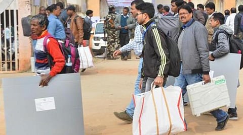 எலெக்ட்ரானிக் வாக்குப்பதிவு எந்திரங்களுடன் தேர்தல் அலுவலர்கள்.