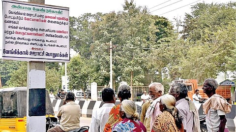 வேங்கிக்கால் ஊராட்சி மன்ற அலுவலகம் அருகே மின் கம்பத்தில் கட்டப்பட்டுள்ள அறிவிப்பை படிக்கும் கிராம மக்கள்.
