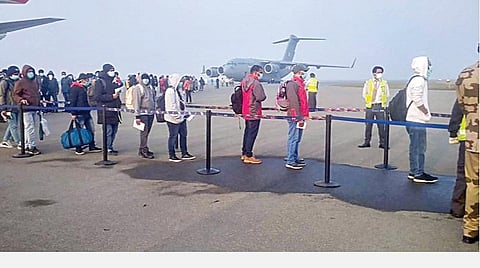 சீனாவின் வூஹான் நகரத்திலிருந்து விமானப்படை விமானத்தில் டெல்லிக்கு நேற்று அழைத்து வரப்பட்ட இந்தியர்கள், சிறப்பு முகாம்களுக்கு செல்வதற்காக வரிசையில் காத்திருந்தனர்.படம்: பிடிஐ