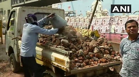 டெல்லி வடகிழக்கில் கலவரத்தின் போது வீசப்பட்ட கற்களை அப்புறப்படுத்தும் துப்புரவுத் தொழிலாளர்கள்: படம் | ஏஎன்ஐ.