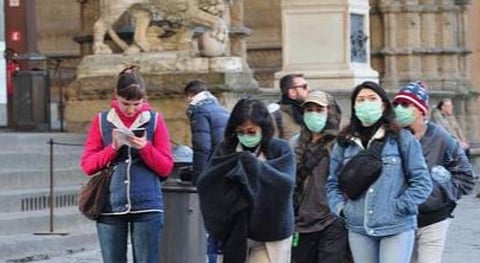 இத்தாலியில் கரோனா வைரஸ் காரணமாக முகக் கவசம் அணிந்துள்ள மக்கள்.