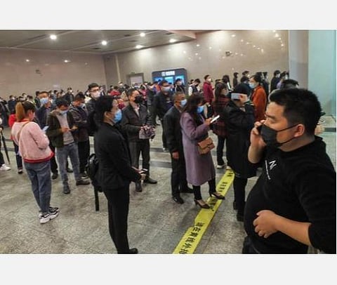 ஹூபே மாகாணத்தில் யிச்சாங் ரயில் நிலையத்தில் டிக்கெட்டுகள் வாங்க காத்திருக்கும் பயணிகள்.| ஏ.எஃப்.பி.