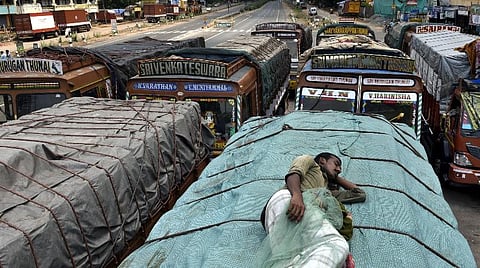 விழுப்புரம் மாவட்ட எல்லையில் வரிசையாக காவல்துறை பாதுகாப்புடன் நிறுத்தி வைக்கப்பட்டுள்ள மதுபான லாரிகள். படம் | எம்.சாம்ராஜ்.