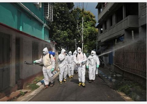 கொல்கத்தாவில் கிருமி நாசினி தெளிக்கும் மாநகராட்சி ஊழியர்கள்.