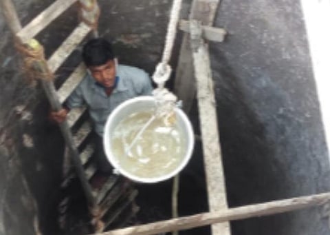 கிணற்றைத் தூர்வாரும் இளைஞர்