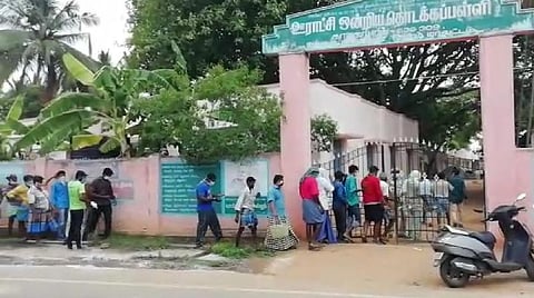 ஊராட்சி ஒன்றியத் தொடக்கப்பள்ளியில் டோக்கன் வாங்க வரிசையில் நிற்பவர்கள்.