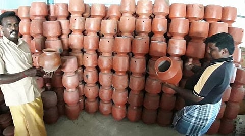 விற்பனைக்கு அனுப்ப முடியாத மண்பானைகளுடன் மண்பாண்டத் தொழிலாளர்கள்.