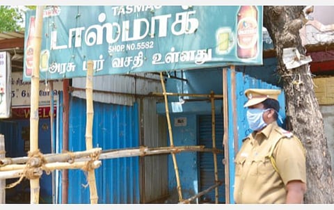 கூடல்நகரில் உள்ள ஒரு டாஸ்மாக் கடை முன் பாதுகாப்புப் பணியில் ஈடுபட்டுள்ள போலீஸ்காரர். படம்: எஸ்.கிருஷ்ணமூர்த்தி