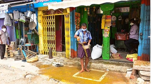ஊரடங்கால் கிழமாசிவீதியில் நீண்டநாட்களுக்குப் பின், கடையைத் திறந்த உரிமையாளர் கடை வாசல் முன் மஞ்சள் தண்ணீர் தெளித்தார்.| படம் எஸ்.கிருஷ்ணமூர்த்தி