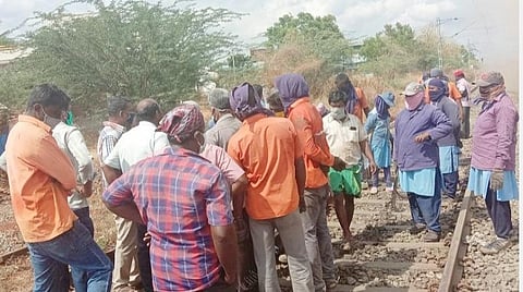 திண்டுக்கல் ரயில்நிலையம் அருகே சமூக இடைவெளி இன்றி தண்டவாளம் சீரமைப்பு பணியில் ஈடுபட்டுள்ள தொழிலாளர்கள்.