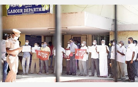 புதுச்சேரியில் உள்ள தொழிற்சாலைகளில் வேலை நேரத்தை 12 மணி நேரமாக அதிகரித்துள்ளதைக் கண்டித்து தொழிலாளர் நலத் துறை அலுவலகத்தை முற்றுகையிட்டு நேற்று தர்ணாவில் ஈடுபட்ட ஏஐடியுசி தொழிற்சங்கத்தினர்.படம்: எம்.சாம்ராஜ்