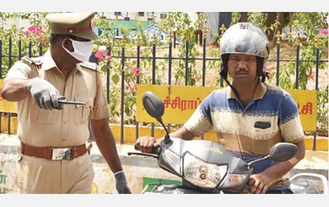 திருச்சி பாலக்கரை மேம்பாலம் சந்திப்பு அருகே முகக்கவசம் அணியாமல் நேற்று இருசக்கர வாகனங்களில் சென்றவர்களை பிடித்து அபராதம் விதிக்கும் காவல் துறையினர். படம்: ஜி.ஞானவேல்முருகன்