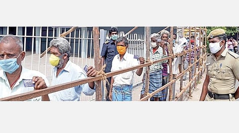 டாஸ்மாக் கடைகளை திறக்க உச்ச நீதிமன்றம் அனுமதி வழங்கியுள்ளதை தொடந்து கோவை ஆர்.எஸ்.புரம் டாஸ்மாக் கடையில் மது வாங்குவதற்காக நேற்று டோக்கனுடன் காத்திருக்கும் மதுப்பிரியர்கள். படம்: ஜெ .மனோகரன்