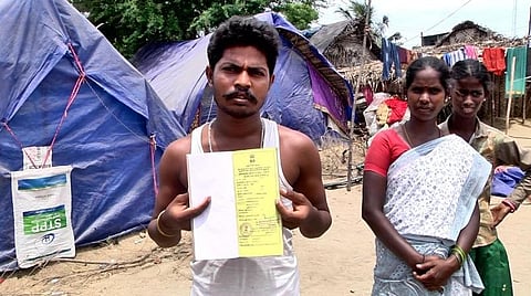 தார்பாய் வீட்டில் வசிக்கும் பழங்குடியின மக்களுக்கு தரப்பட்டுள்ள மஞ்சள் ரேஷன் கார்டு.