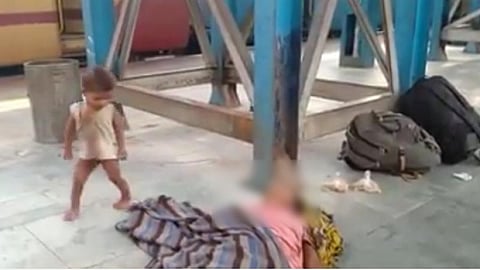 முசாபர்பூரில் ரயில்வே நடைபாதையில் இறந்து கிடந்த தாயின் உடல் அருகே இருக்கும் குழந்தை.
