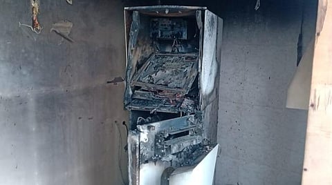 ஏடிஎம் மையத்தில் நடந்த கொள்ளை முயற்சியின்போது ஏற்பட்ட தீ விபத்தில் ஏடிஎம் இயந்திரம் உருக்குலைந்து காணப்படுகிறது.