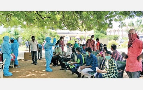 திருச்சி அரசு மருத்துவமனையில் கரோனா பரிசோதனைக்கு சளி மாதிரியைப் பெறும் இடமான மரத்தடியில் நேற்று காத்திருந்தோர். படங்கள்: ஜெ.ஞானசேகர்