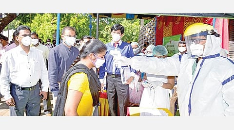 மதுரை முடக்குச்சாலையில் காய்ச்சல் கண்டறியும் முகாமில் பெண் ஒருவருக்கு உடல் வெப்பநிலைப் பரிசோதனை செய்வதைப் பார்வையிட்ட சுகாதாரத் துறை முதன்மைச் செயலாளர் ராதாகிருஷ்ணன். உடன், மாவட்ட ஆட்சியர் டிஜி வினய், மாநகராட்சி ஆணையர் விசாகன்.படம்: எஸ்.கிருஷ்ணமூர்த்தி