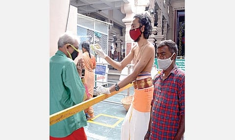 நங்கநல்லூர் ஆஞ்சநேயர் கோயில் 5 மாதங்களுக்குப் பிறகு நேற்று திறக்கப்பட்டது. பக்தர்கள் உடல் வெப்பநிலை பரிசோதனைக்குபின் கோயிலுக்குள் அனுமதிக்கப்பட்டனர். படம்: எம்.முத்துகணேஷ்