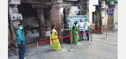 மதுரை மீனாட்சி அம்மன் கோயிலில் லட்டு பிரசாதத்தை பெறும் பக்தர்கள்.