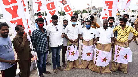 திருச்சி காவிரிப் பாலத்தில் நூதனப் போராட்டத்தில் ஈடுபட்ட இந்திய ஜனநாயக வாலிபர் சங்கத்தினர். | படம்: ஜி.ஞானவேல்முருகன்.