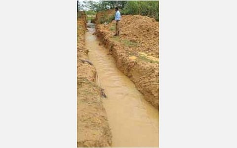 பேயம்பட்டி கிராமத்தில் கிராவல் குவாரிக்கு இடையூறாக இருப்பதாக கண்மாய்க் கரையை உடைத்து வெளியேற்றப்படும் தண்ணீர்.