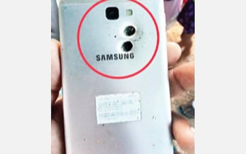 வாணியம்பாடி அரசு மருத்துவமனையில் சிகிச்சை பெற்று வரும் வேலாயுதம். அடுத்த படம்: நாட்டு துப்பாக்கியால் சுட்டதில் செல்போனில் பின்பகுதியில் பாய்ந்த இரண்டு பால்ஸ் உருளைகளால் சேதமடைந்துள்ளது.