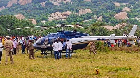 திருப்பத்தூர் அடுத்த தாதன்குட்டை கிராமத்தில் சாலையோரம் உள்ள விவசாய நிலத்தில் தரையிறக்கப்பட்ட ஹெலிகாப்டர்.