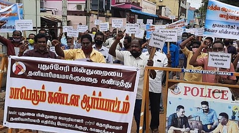காரைக்கால் தலைமை தபால் நிலையம் முன்பு ஆர்ப்பாட்டத்தில் ஈடுபட்ட மின்துறை ஊழியர்கள்.