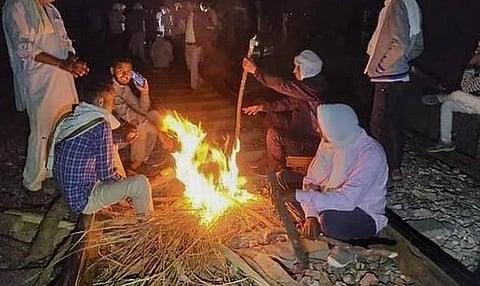 நேற்று இரவு ரயில் தடத்தைவிட்டு அகலாமல் மறியலில் ஈடுபட்ட குர்ஜார் மக்கள் | படம்: பிடிஐ.