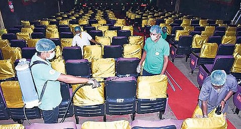 கடலூரில் உள்ள ஒரு தியேட்டரில் கிருமிநாசினி தெளிக்கும் பணி நடக்கிறது.