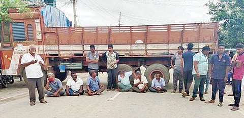 கிருஷ்ணகிரியில் சென்னை சாலையில் மைய தடுப்பு அமைக்க எதிர்ப்பு தெரிவித்து மறியல் போராட்டத்தில் ஈடுபட்ட லாரி ஓட்டுநர்கள்.