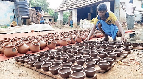 திருநெல்வேலி அருகே குறிச்சியில் திருக்கார்த்திகைக்காக தயாரான அகல் விளக்குகளை உலர வைக்கும் பணியில் ஈடுபட்டுள்ள சிறுவன். படம்: மு.லெட்சுமி அருண்.