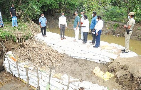 கல்பட்டு ஊராட்சியில் நீர் வரத்து வாய்க்காலில் ஏற்பட்ட உடைப்பினை பார்வையிடும் விழுப்புரம் மாவட்ட ஆட்சியர் அண்ணாதுரை.
