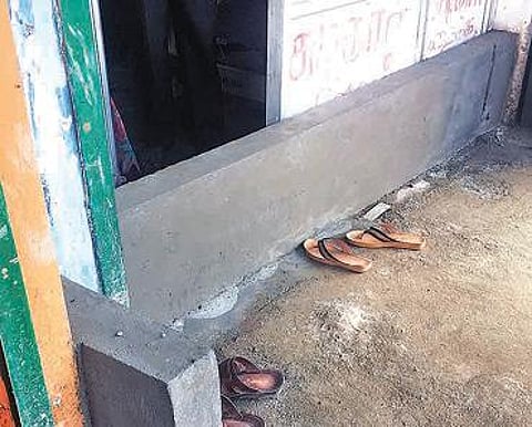 சாலை மட்டத்தைவிட உயரமாக கட்டப்பட்ட சிறு பாலத்தால் கடைகளுக்குள் கழிவுநீர் புகுவதாக வியாபாரிகள் புகார்