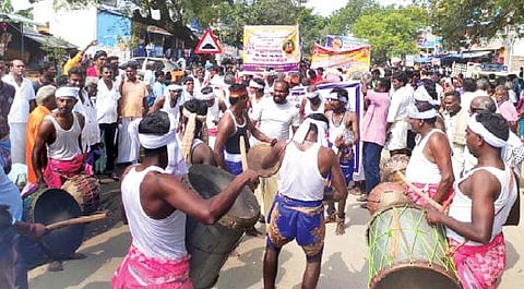 நாட்டுப்புற கலைஞர்கள் ஊர்வலமாக ஆடிப்பாடி வருகின்றனர்.