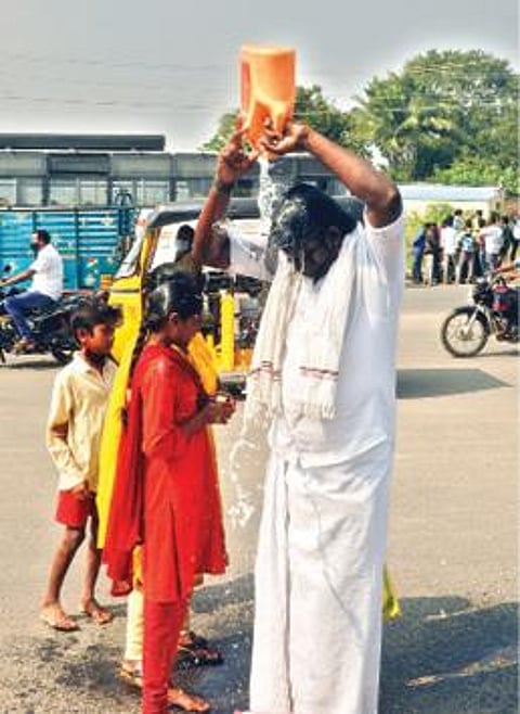 தி.மலை மாவட்ட ஆட்சியர் அலுவலக நுழைவு வாயில் முன்பு தீக்குளிக்க முயன்ற விவசாயி சரவணன்.