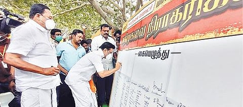 வாலாஜா அடுத்த அனந்தலை ஊராட்சியில் நடந்த மக்கள் கிராம சபை கூட்டத்தில் அதிமுகவை நிராகரிக்கிறோம் என வைக்கப்பட்டிருந்த பேனரில் கையெழுத்திட்ட திமுக தலைவர் மு.க.ஸ்டாலின். அருகில், எம்எல்ஏ காந்தி உள்ளிட்டோர்.