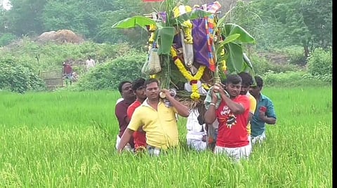 கொடுக்கூர் கிராமத்தில் உயிரிழந்த கரைமேல் என்பவரின் உடலை விளைநிலம் வழியே சுமந்து செல்லும் அவரது உறவினர்கள்