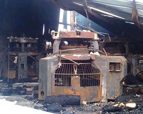 திருப்பூர் பாண்டியன் நகரில் உள்ள நிட்டிங் நிறுவனத்தில் ஏற்பட்ட தீ விபத்தில் எரிந்து சேதமான இயந்திரங்கள்.